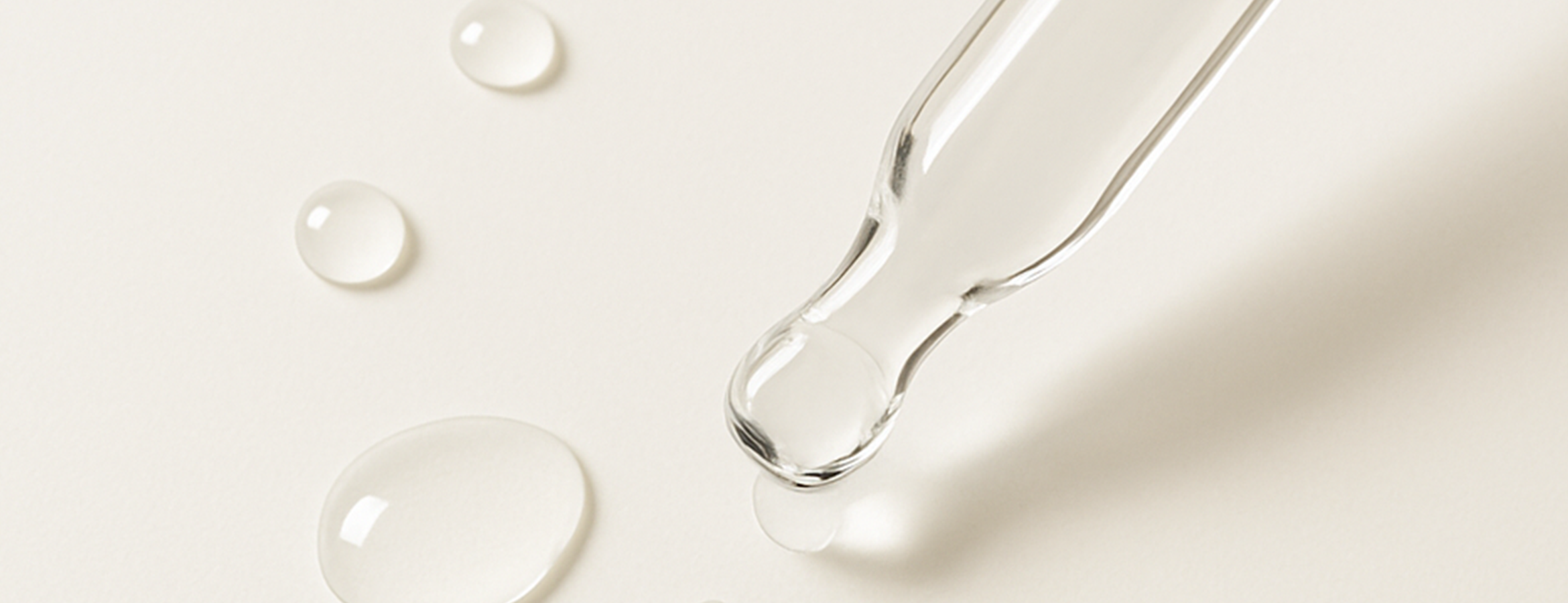 スポイトと透明な液体のしずくのキービジュアル